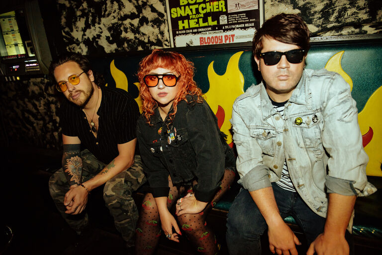 Glass Mansions band members sitting on a couch
