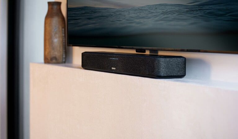 A sound bar sitting on a hearth