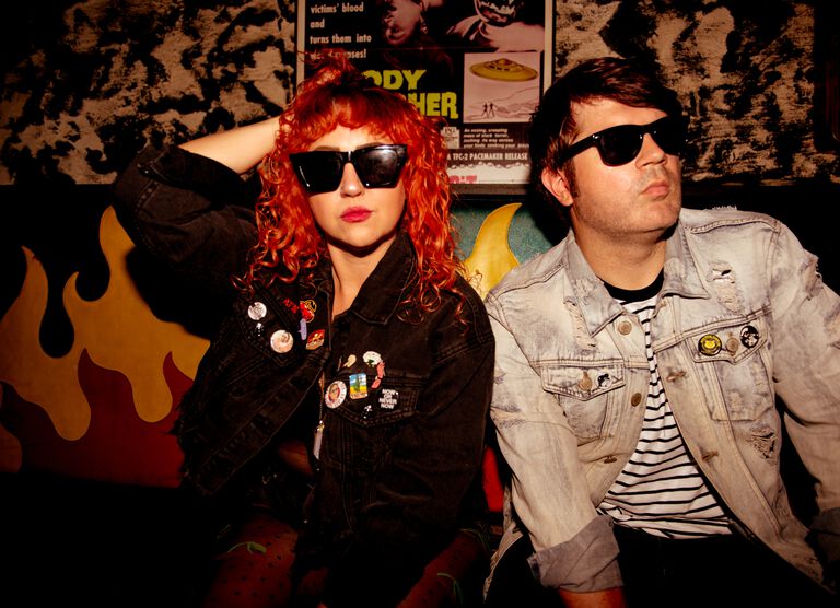 Glass Mansions band members sitting on a couch