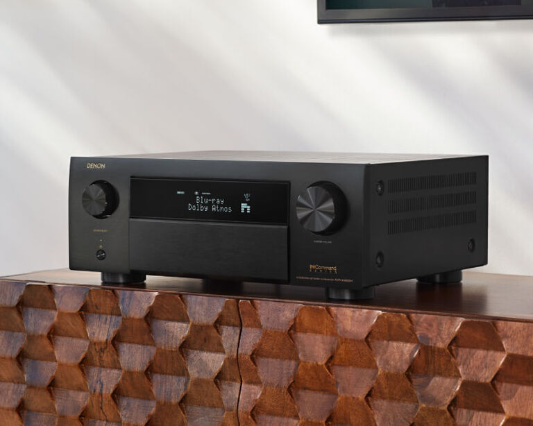 Denon AV Receiver sitting on an entertainment console