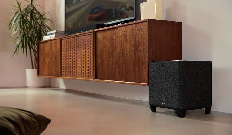 A subwoofer sitting on the floor of a tv room